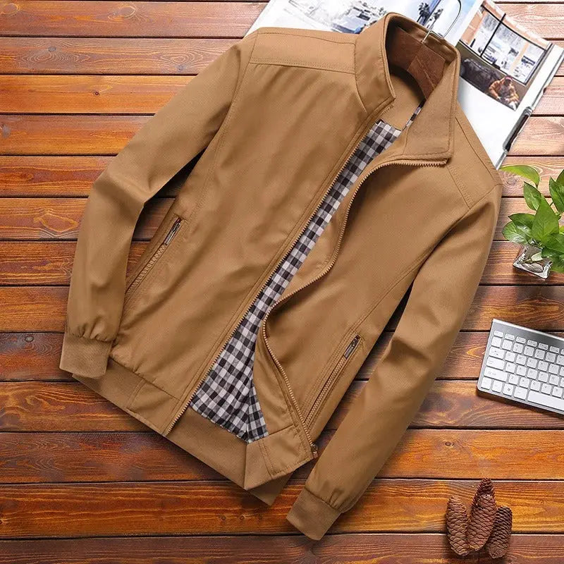 Giacca casual da uomo marrone chiaro su tavolo in legno, con fodera a quadri, zip frontale, polsini elasticizzati. Moda autunnale elegante.