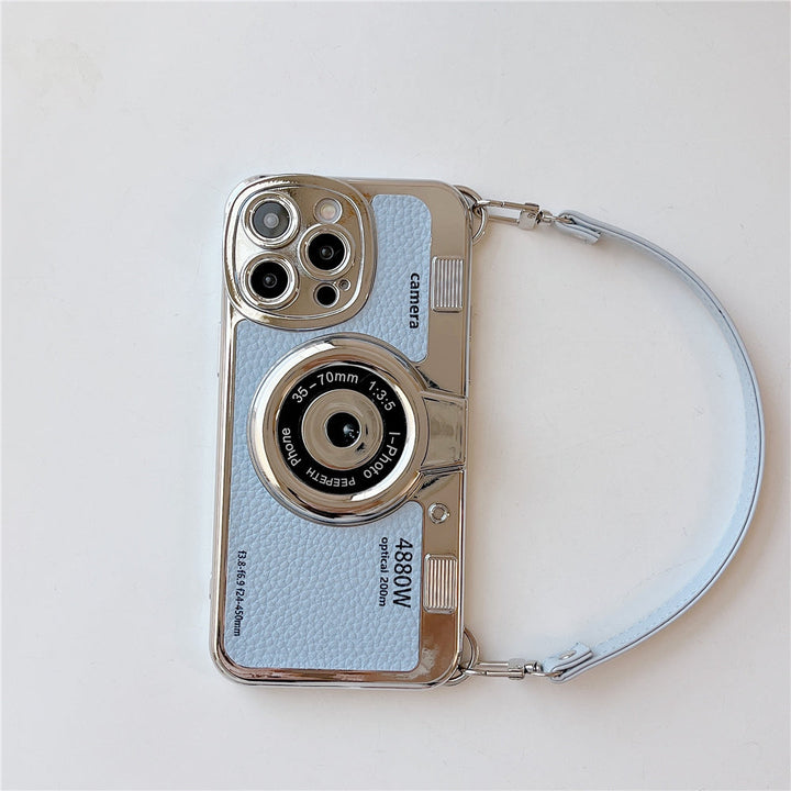 Custodia per iPhone a forma di fotocamera vintage, colore azzurro, con dettagli argentati e cinturino. Design unico, accessorio moda per smartphone.
