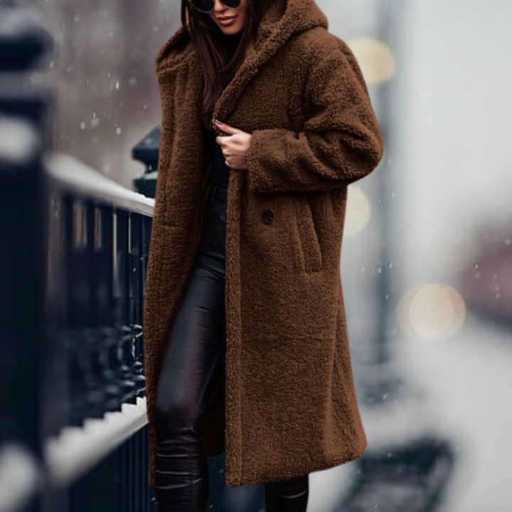 Cappotto lungo in pelliccia sintetica marrone, donna in strada innevata, moda invernale elegante, cappuccio, abbigliamento caldo e trendy.