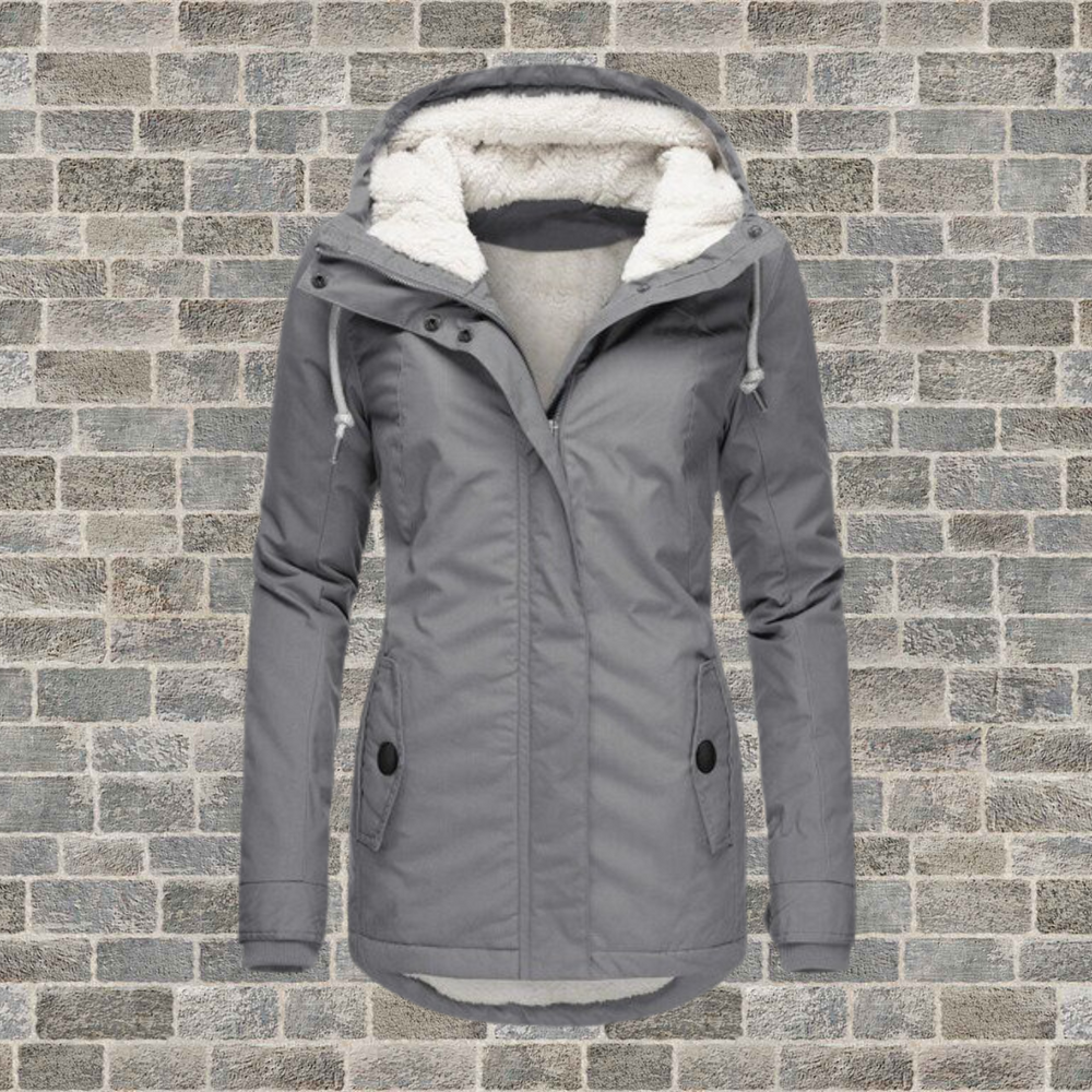 Giacca invernale da donna grigia con cappuccio foderato in pelliccia sintetica, chiusura a zip, tasche frontali, ideale per climi freddi.
