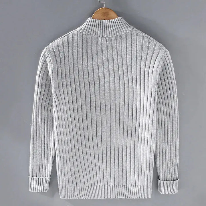 Maglione grigio a coste, maniche lunghe, collo alto, su gruccia. Design elegante e caldo, ideale per moda autunno-inverno uomo.