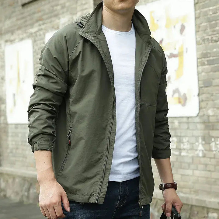 Giacca verde militare da uomo, stile casual, con zip, indossata su maglietta bianca. Ideale per moda urbana e abbigliamento autunnale.