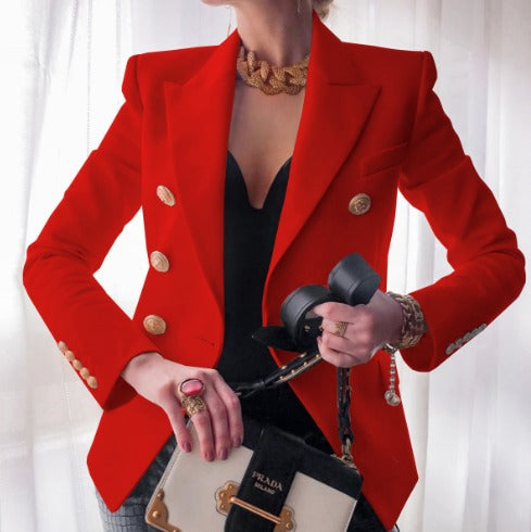 Donna con giacca rossa elegante, bottoni dorati, collana vistosa, borsa Prada bianca e nera, sfondo bianco. Moda di lusso, stile sofisticato.