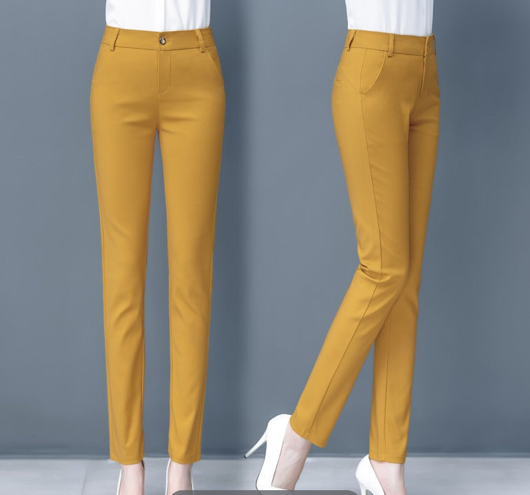 Pantaloni donna giallo senape eleganti, taglio slim fit, vita alta, tasche laterali, chiusura con bottone, abbinati a scarpe bianche con tacco.