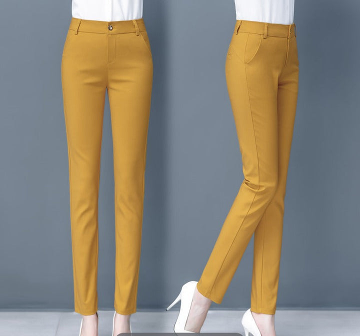 Pantaloni donna giallo senape eleganti, taglio slim fit, vita alta, tasche laterali, chiusura con bottone, abbinati a scarpe bianche con tacco.