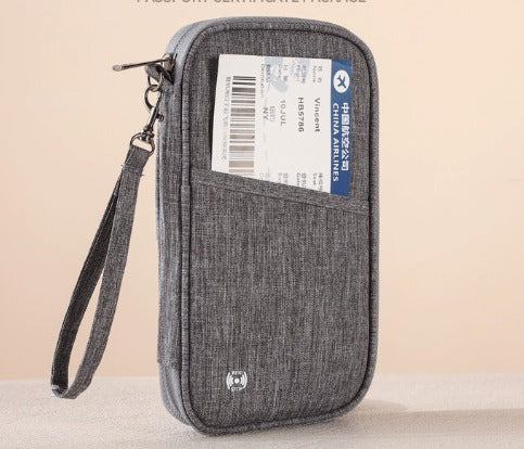 Custodia da viaggio grigia con cerniera, tasca frontale contenente un biglietto aereo. Design compatto, ideale per documenti e accessori da viaggio.