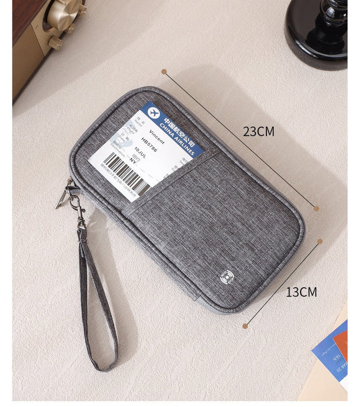 Custodia da viaggio grigia 23x13 cm con cerniera e cinturino, ideale per documenti e biglietti. Accessorio pratico ed elegante per viaggiatori.