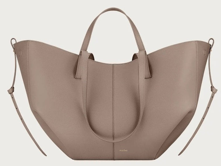 Borsa a mano in pelle beige, design elegante e moderno, con manici corti e dettagli laterali. Accessorio di moda per donna.