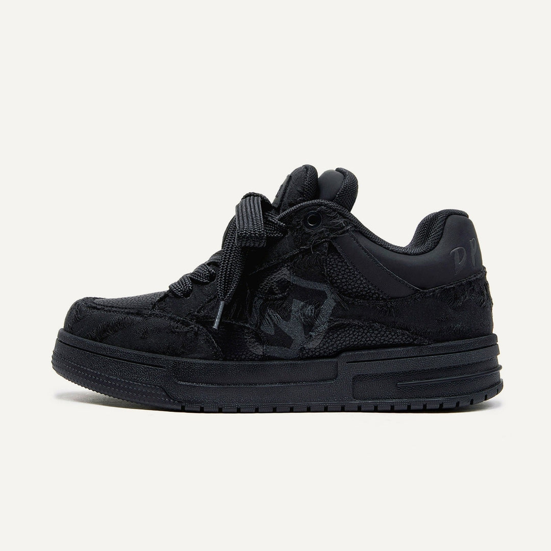 Black suede sneaker with textured design, featuring a prominent logo on the side, thick sole, and black laces. Stylish footwear for casual wear.