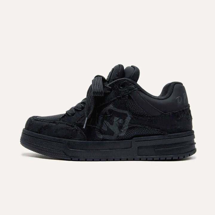 Black suede sneaker with textured design, featuring a prominent logo on the side, thick sole, and black laces. Stylish footwear for casual wear.
