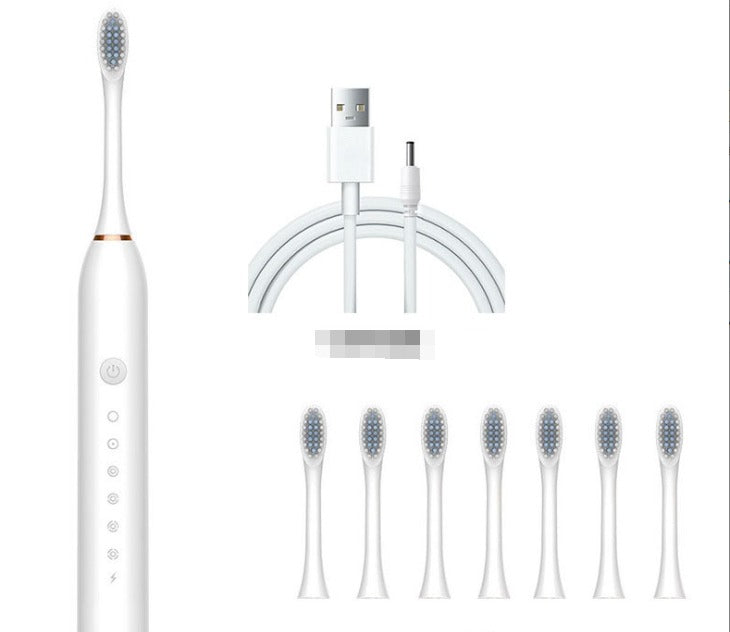 Spazzolino elettrico bianco con testine di ricambio, cavo USB per ricarica. Design moderno, set completo per igiene orale avanzata.