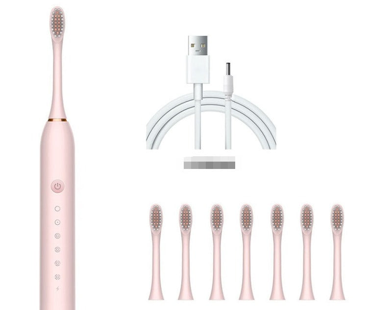 Spazzolino elettrico rosa con setole intercambiabili, caricatore USB e sette testine di ricambio. Accessorio per igiene orale avanzata.