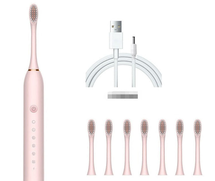 Spazzolino elettrico rosa con setole intercambiabili, caricatore USB e sette testine di ricambio. Accessorio per igiene orale avanzata.
