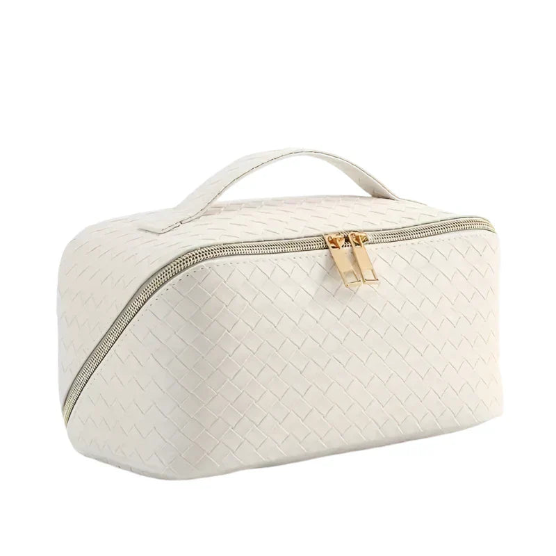 Astuccio da viaggio in pelle intrecciata bianca con cerniera dorata e manico superiore. Elegante e pratico per cosmetici e accessori.