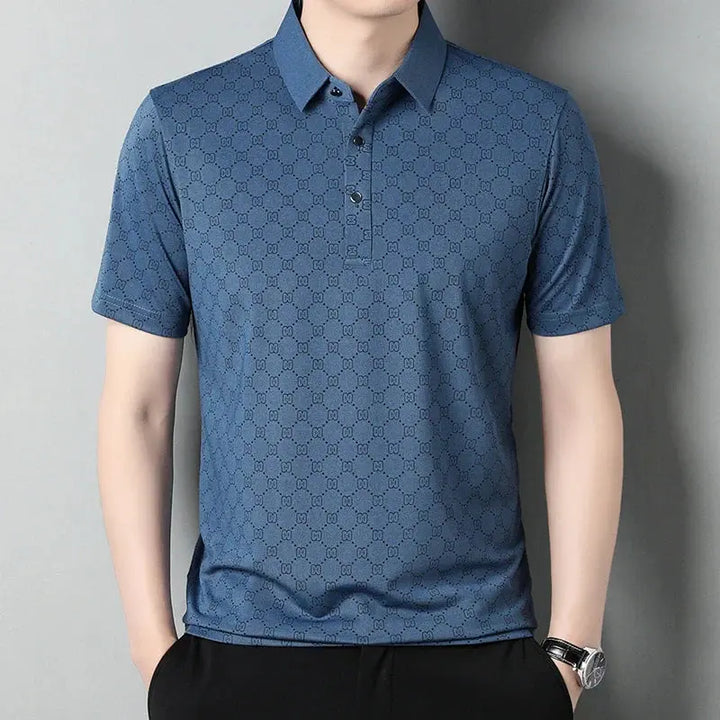 Maglietta polo uomo blu con motivo geometrico, maniche corte, colletto classico, abbigliamento casual elegante, moda maschile estiva.