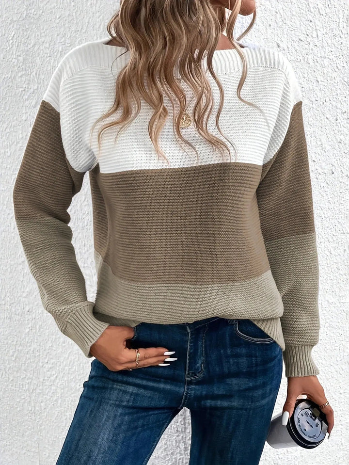 Maglione a righe bianche e marroni, donna con capelli ondulati, jeans blu, tiene una tazza. Moda autunnale casual, abbigliamento femminile trendy.