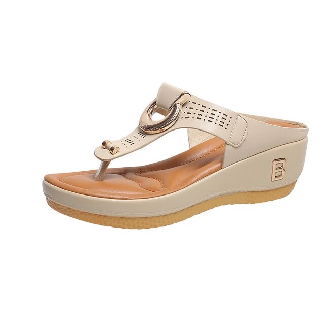 Sandalo donna beige con zeppa, design elegante, cinturino traforato, dettaglio metallico, suola antiscivolo. Calzature estive moda comoda.