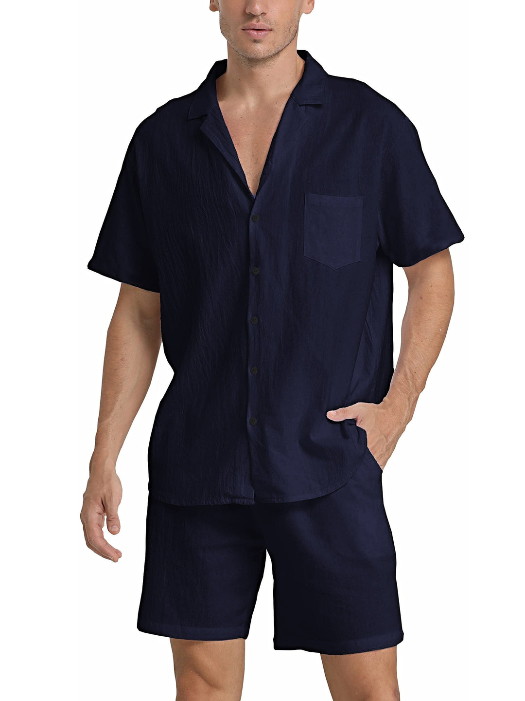 Uomo in completo estivo blu scuro, camicia a maniche corte con colletto e taschino, pantaloncini coordinati. Moda maschile casual elegante.