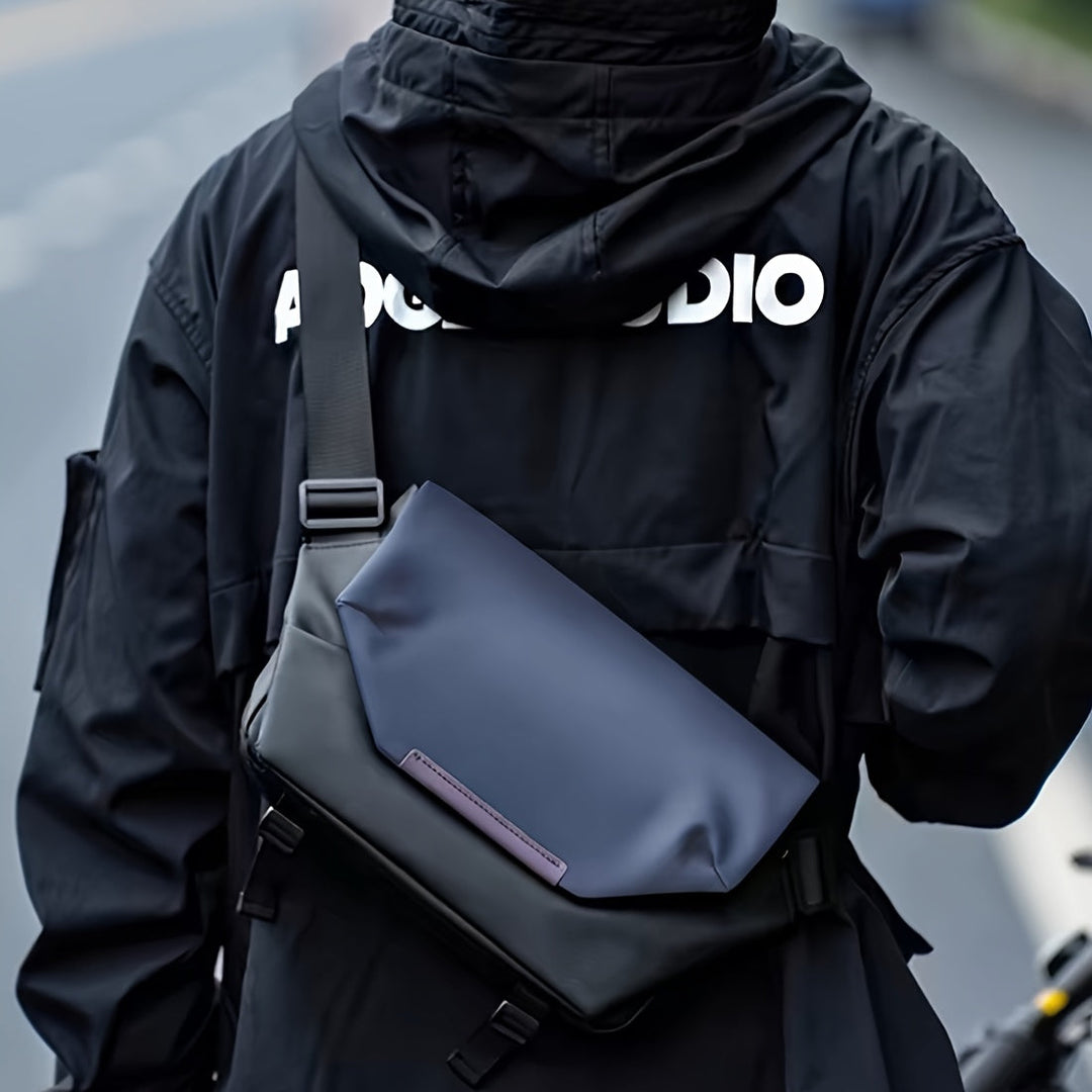 Giacca nera con scritta bianca e borsa a tracolla blu scuro, design moderno, moda urbana, accessorio unisex, stile casual, strada di città.