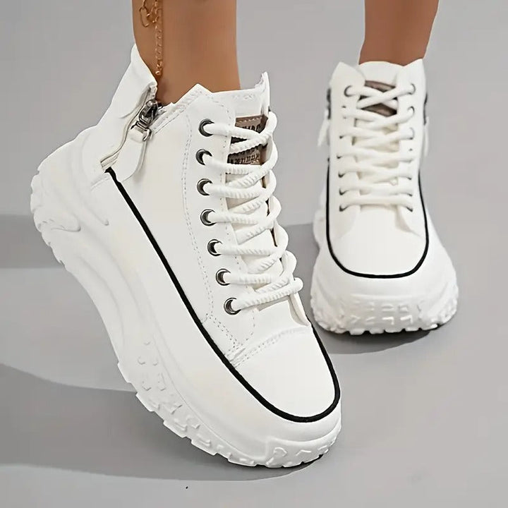 Scarpe da ginnastica bianche con suola spessa, dettagli neri e cerniera laterale. Design moderno e alla moda per un look casual e sportivo.
