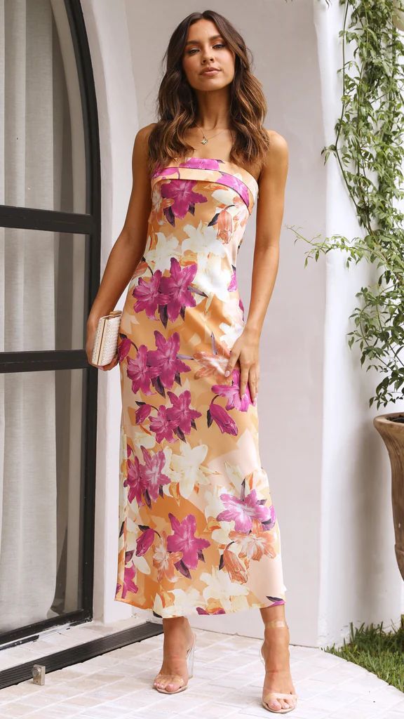 Abito lungo estivo a fiori rosa e arancioni, senza spalline, indossato da una donna. Perfetto per eventi eleganti e cerimonie all&