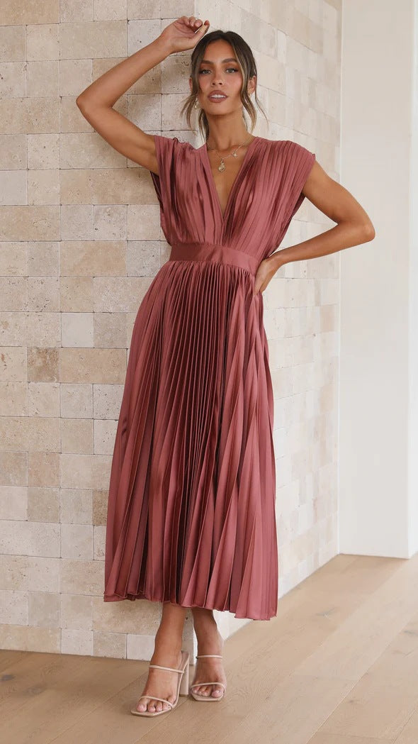 Abito lungo plissettato color terracotta, scollatura a V, senza maniche, elegante e moderno, perfetto per eventi formali e serate speciali.