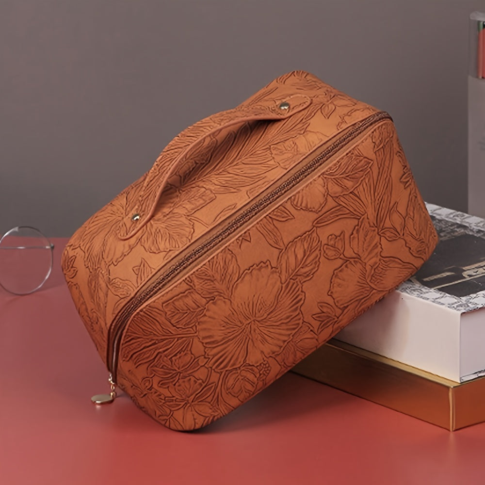 Borsa da trucco in pelle marrone con motivo floreale, chiusura a zip, manico superiore. Elegante e pratica per organizzare cosmetici.