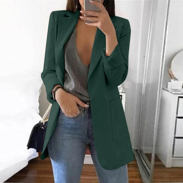 Giacca verde elegante da donna, abbinata a top grigio e jeans, moda casual chic, perfetta per look autunnali.