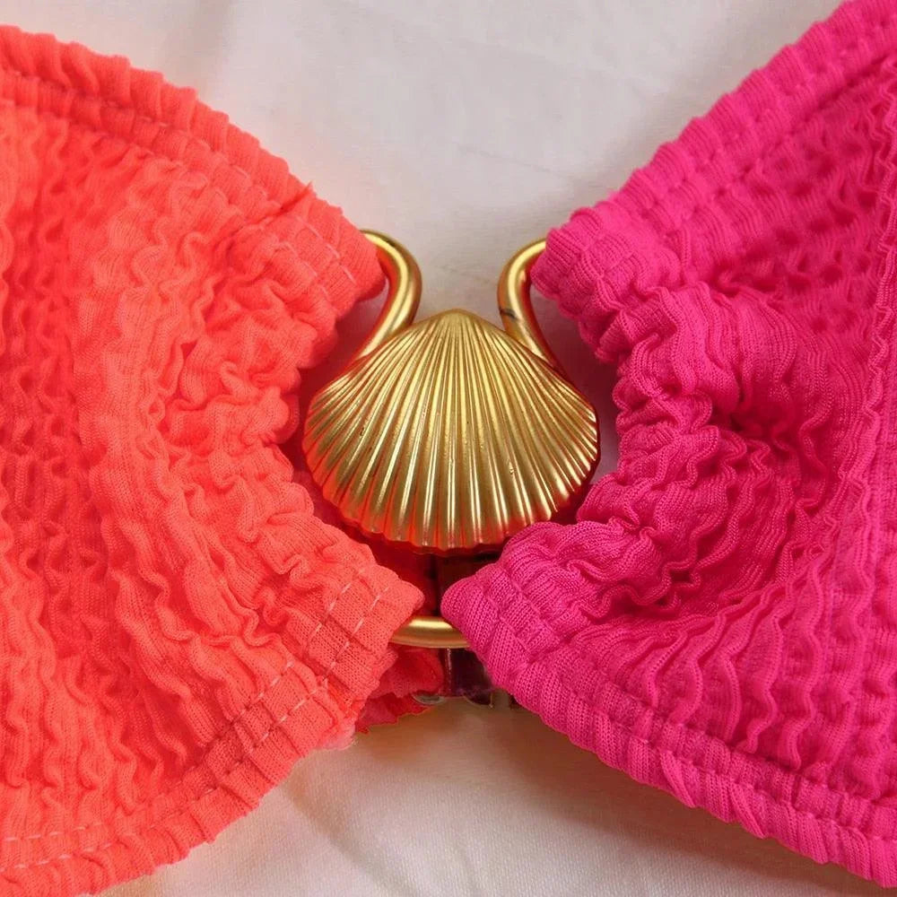 Bikini femme asymétrique en tissu texturé, avec un design élégant et un anneau décoratif au centre.