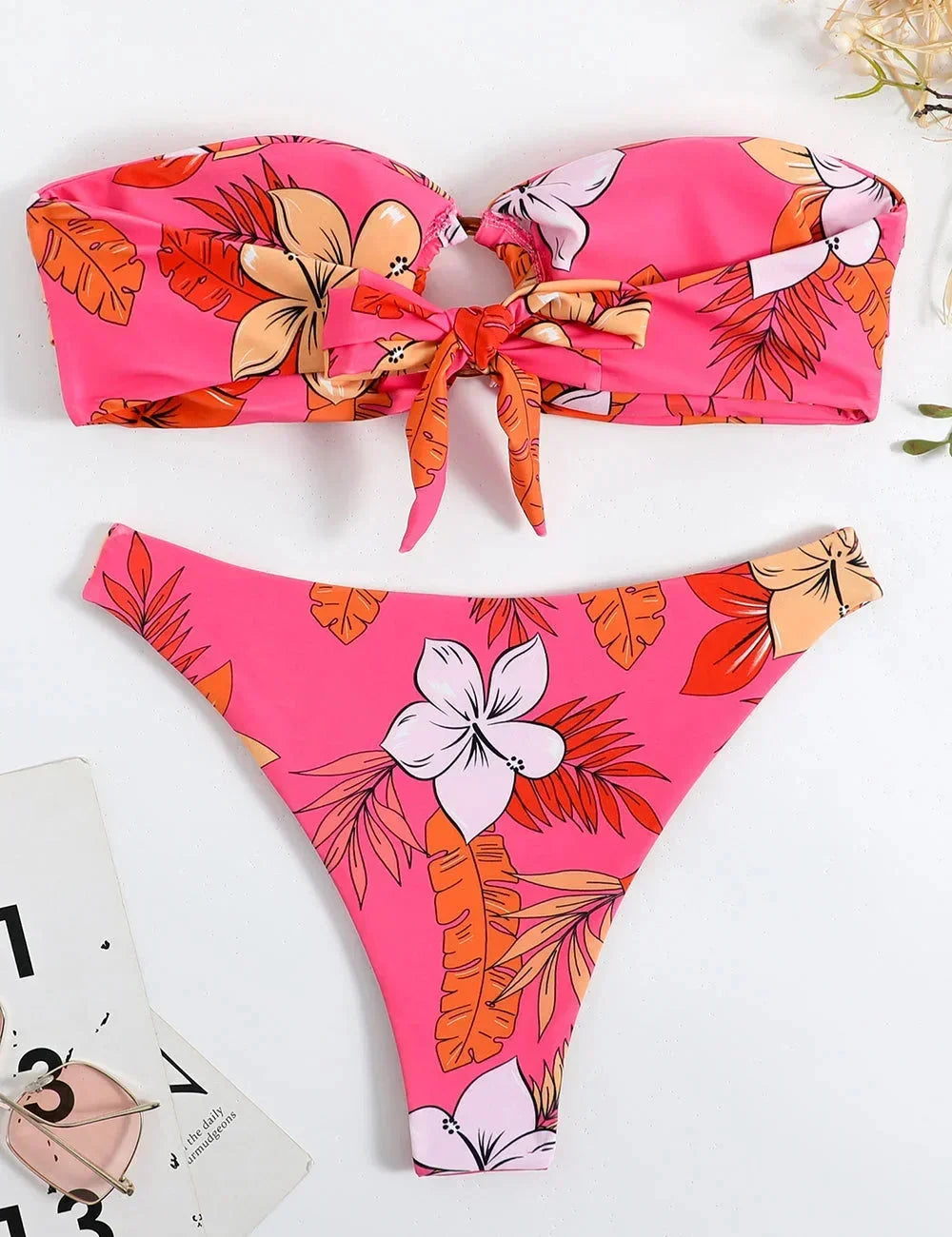 Bikini femme rose bandeau en tissu doux, avec motif floral et anneau décoratif au centre pour un look estival.