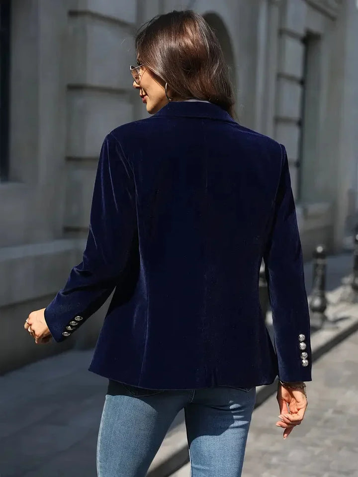 Blazer ajusté en velours bleu marine pour femme, avec boutons décoratifs et coupe cintrée.