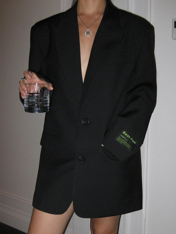 Blazer femme oversize avec boutons, en polyester, coupe décontractée et détails élégants pour des tenues variées.
