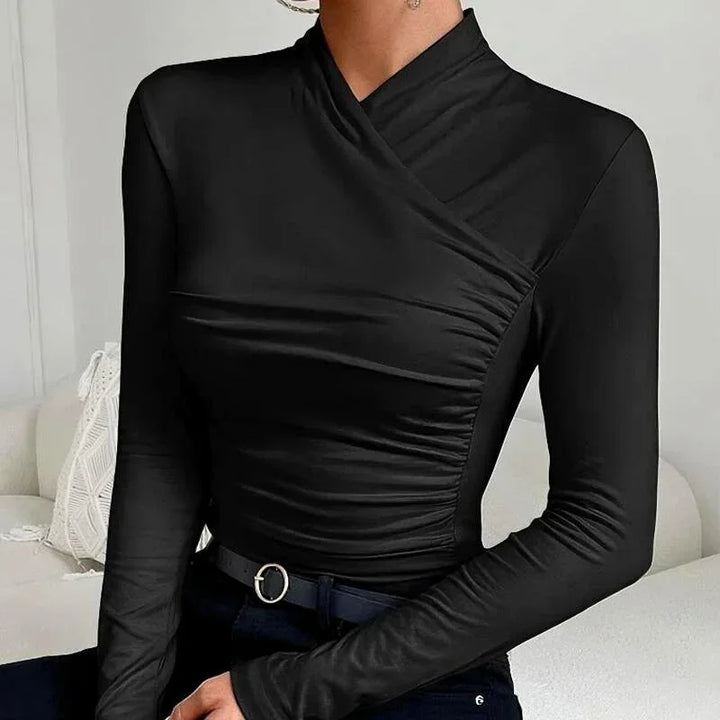 Haut ajusté asymétrique à manches longues pour femme en tissu léger, design moderne et élégant. Couleur blanche.