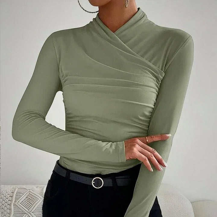 Haut ajusté asymétrique à manches longues en tissu léger, couleur blanche, avec des détails élégants.