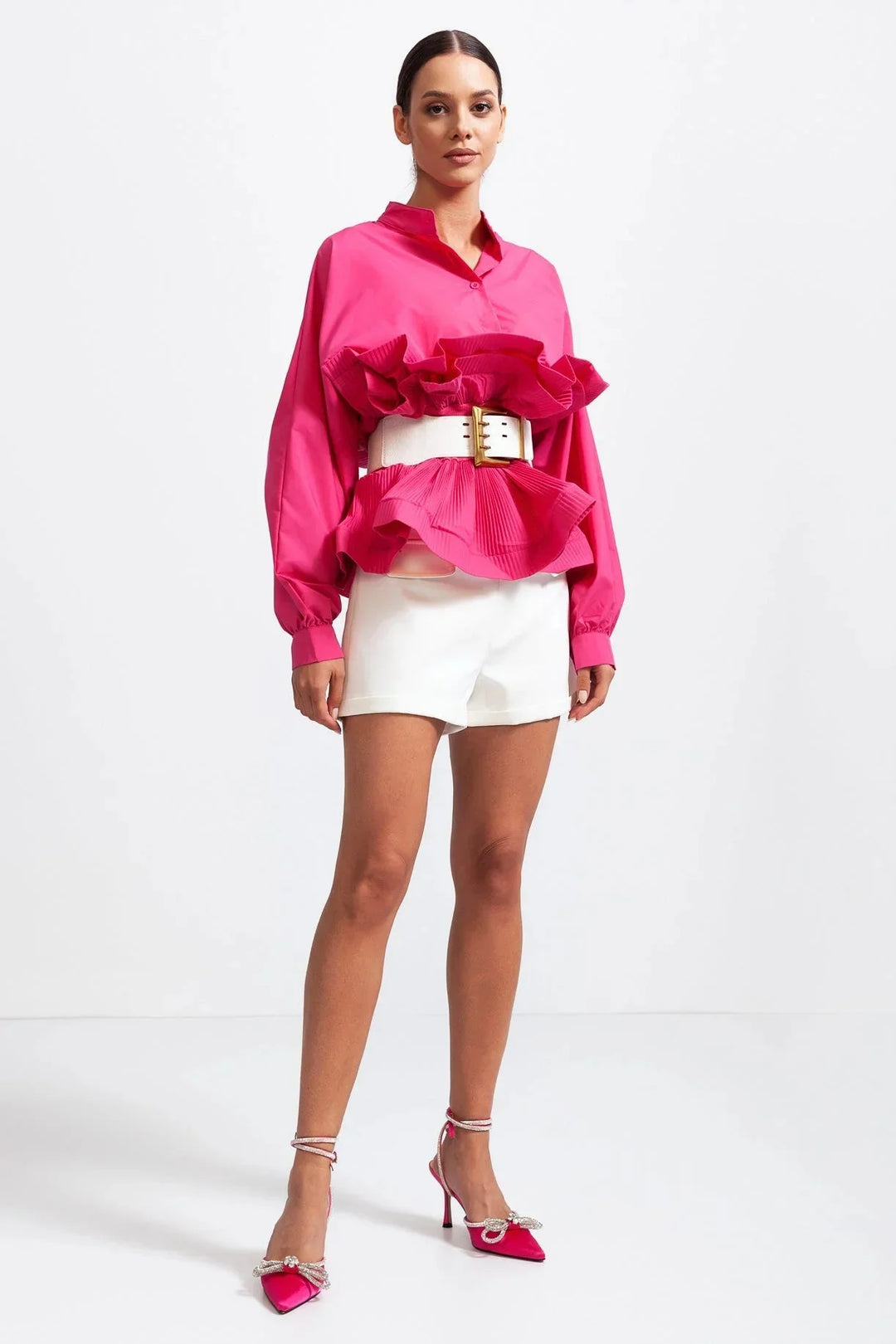 Blouse rose pour femme avec volants et manches volumineuses, en tissu léger et respirant.