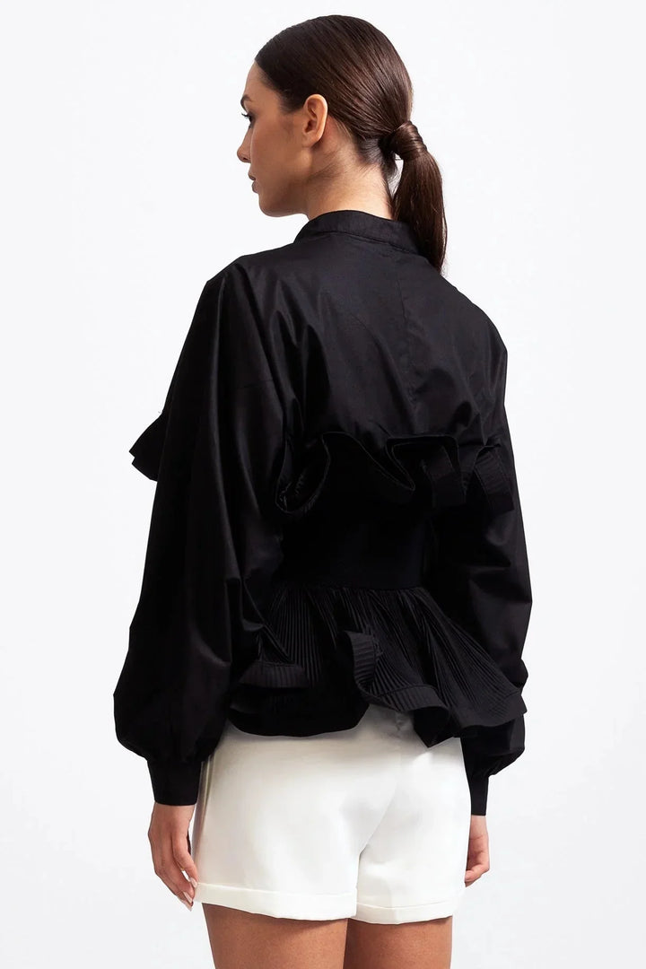 Blouse femme noire avec volants et manches volumineuses en coton léger.