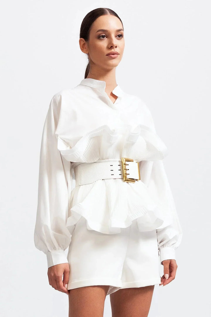 Blouse femme blanche en tissu léger, avec volants et manches volumineuses, au design élégant.