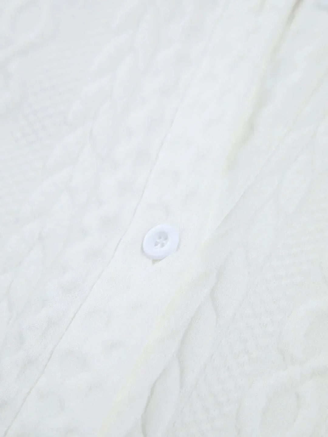 Blouse femme blanche en coton texturé, avec manches sculptées pour un style élégant et distinctif.