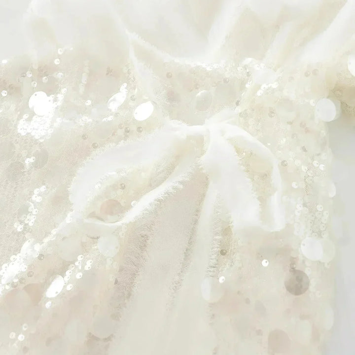 Blouse femme ivoire en tissu léger, ornée de paillettes et dotée d'un col en V pour une coupe élégante et décontractée.