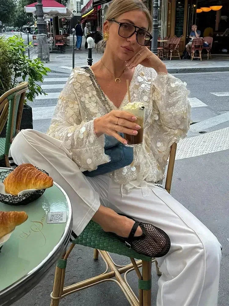 Blouse femme ivoire avec paillettes brodées et col en V, légère et élégante pour une tenue raffinée.