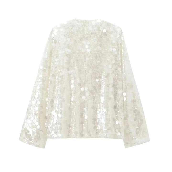 Blouse ivoire à paillettes avec col en V, en tissu léger, parfaite pour une tenue élégante et festive.
