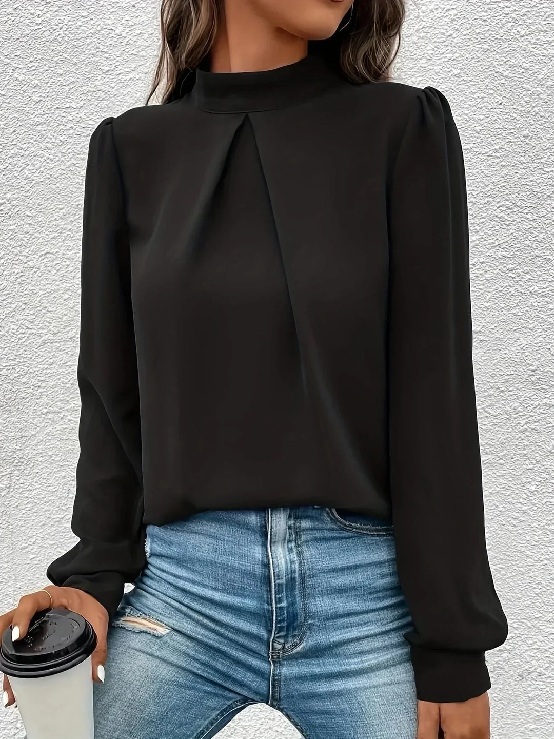 Haut noir à manches longues pour femme, en tissu léger et respirant, avec un design élégant.