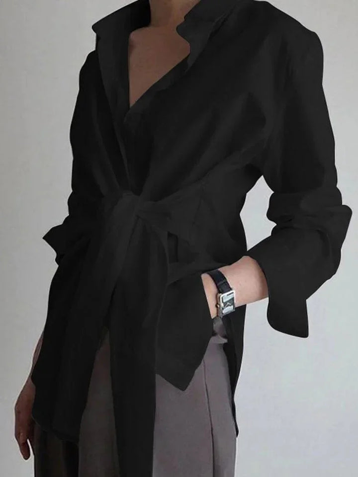 Blouse femme noire nouée devant, manches boutonnées, en tissu léger, idéale pour un style décontracté et élégant.