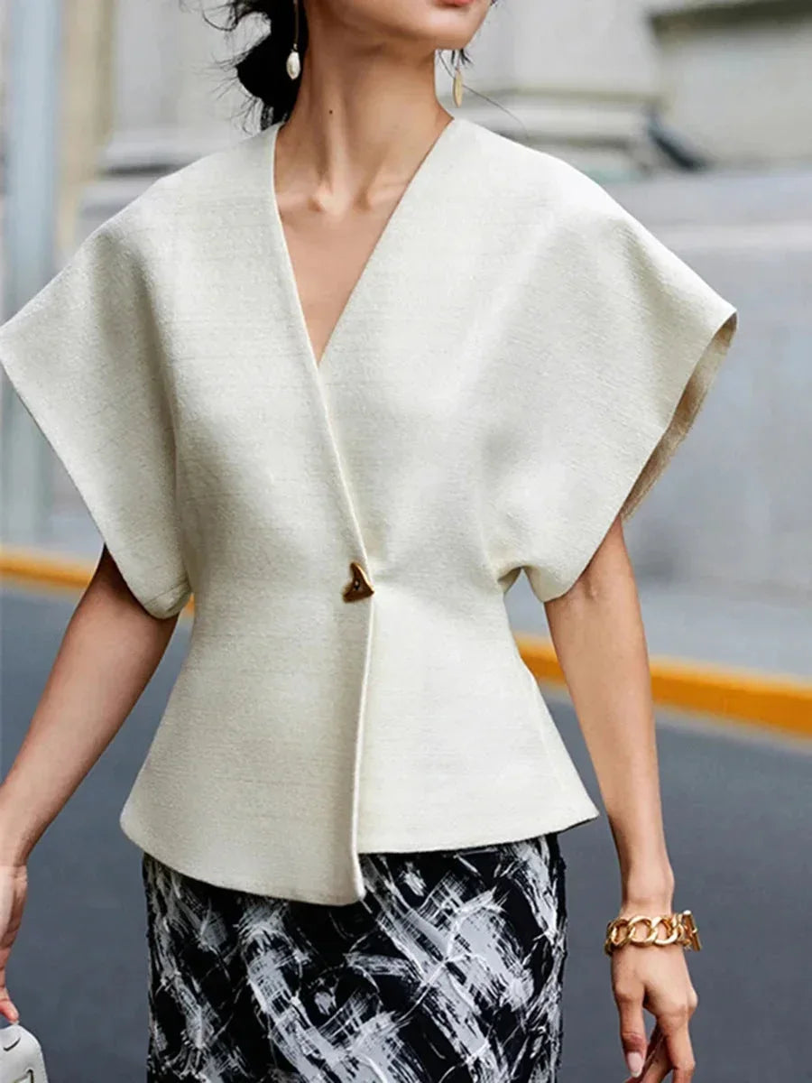 Blouse femme en tissu léger, style cache-cœur avec manches sculptées et silhouette fluide, parfaite pour un look élégant.