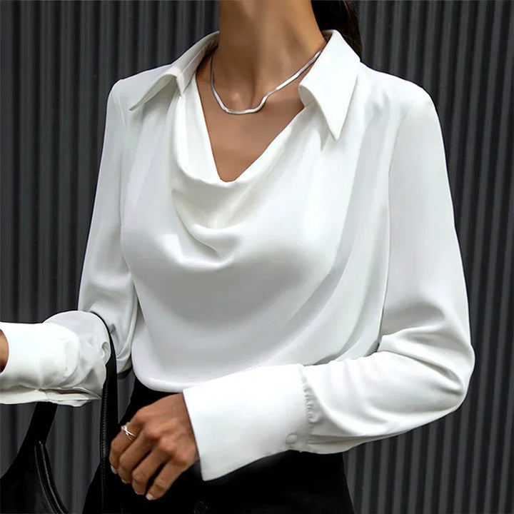 Blouse bleue à col drapé et manches longues, en tissu léger et respirant, coupe élégante.