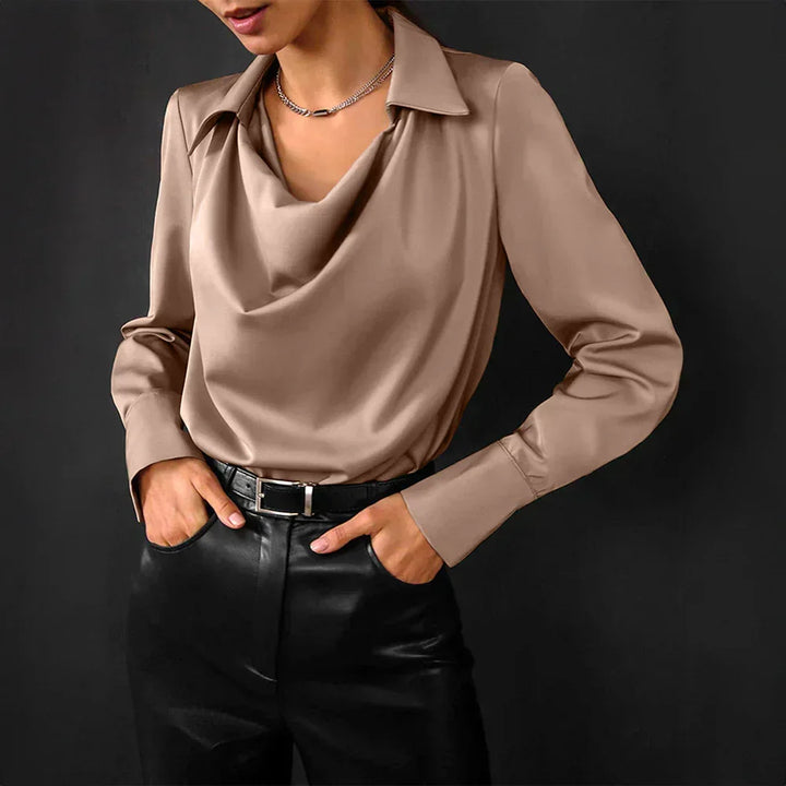Blouse bleue à col drapé et manches longues en tissu doux, adaptée pour des occasions élégantes ou décontractées.