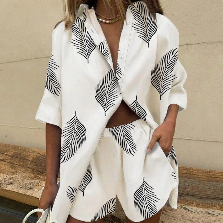 Donna con completo estivo bianco a foglie nere, camicia e shorts coordinati. Moda casual, abbigliamento estivo, stile trendy.