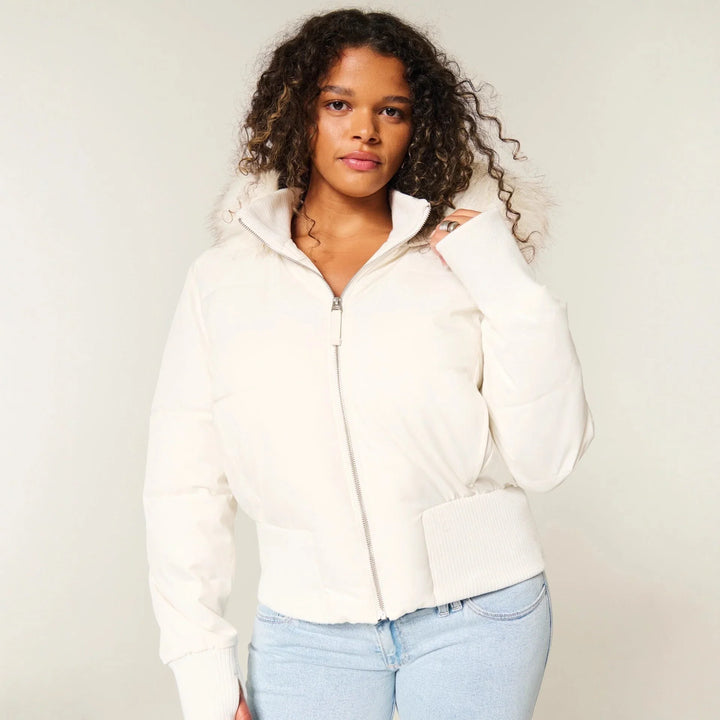 Blouson d’hiver femme noir, matelassé, avec capuche amovible et poches latérales, adapté pour les jours froids.