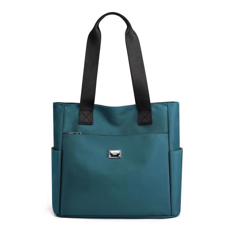 Borsa tote donna in pelle blu con manici neri, tasche laterali e chiusura con zip. Elegante e spaziosa, ideale per l&