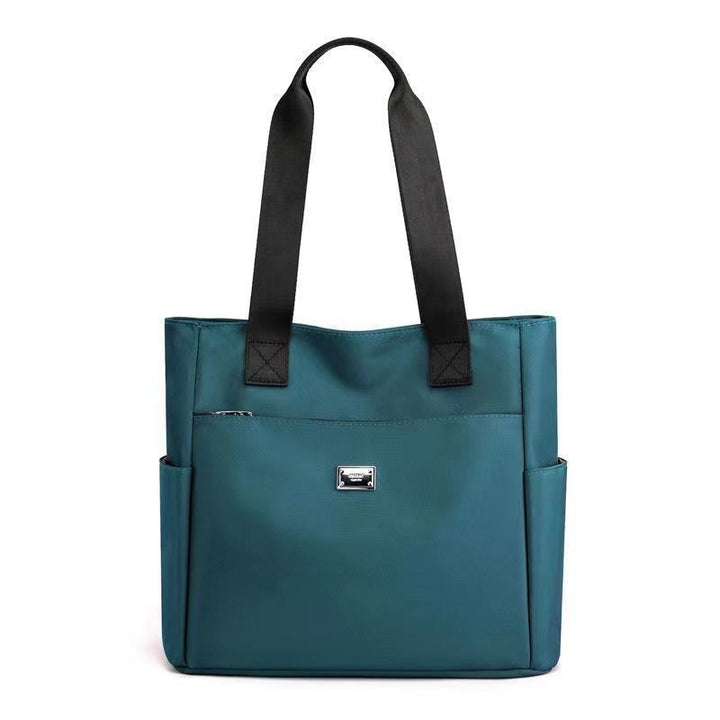 Borsa tote donna in pelle blu con manici neri, tasche laterali e chiusura con zip. Elegante e spaziosa, ideale per l&